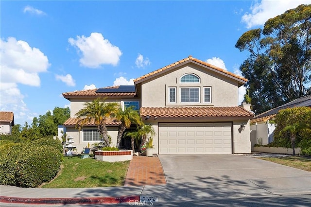 mediterranean / spanish-style home featuring a garage and solar panels