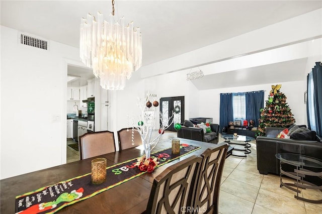 dining space featuring light tile patterned flooring and a notable chandelier