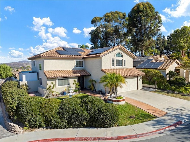 mediterranean / spanish home with solar panels and a garage