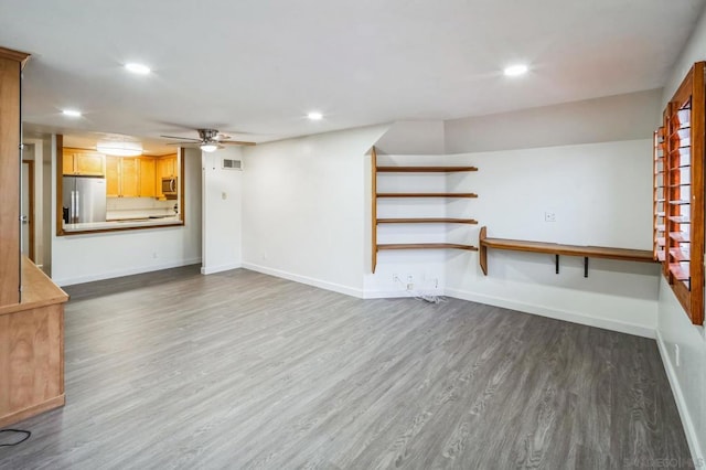 unfurnished living room with ceiling fan and dark wood-type flooring