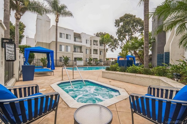 view of swimming pool featuring a community hot tub, a patio, and a gazebo