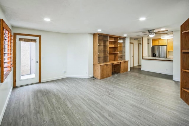 unfurnished living room featuring hardwood / wood-style floors and ceiling fan