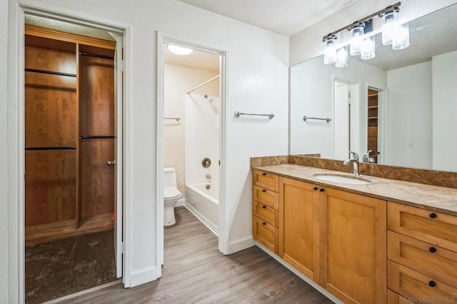 full bathroom featuring toilet, hardwood / wood-style floors, vanity, and washtub / shower combination