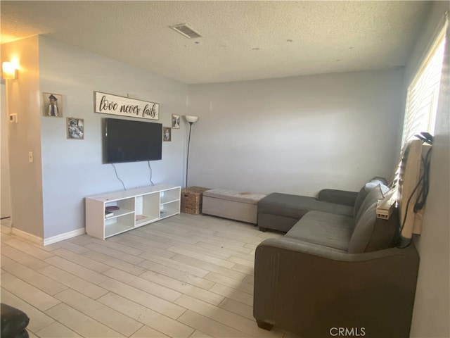 living room featuring a textured ceiling and light wood-type flooring