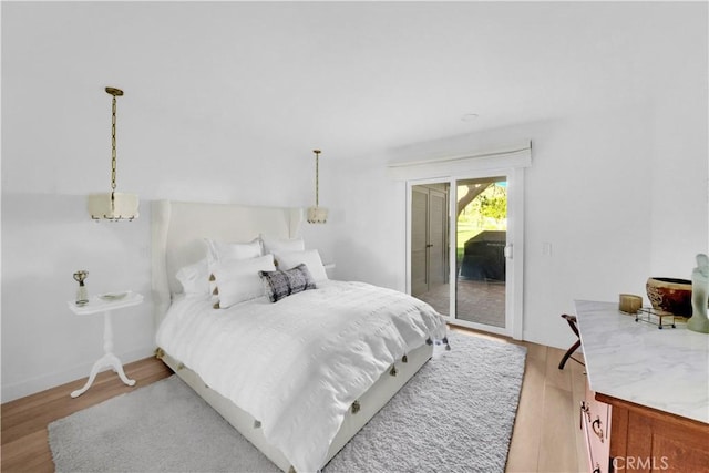 bedroom featuring access to exterior and light hardwood / wood-style floors