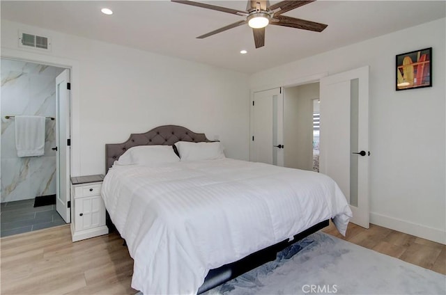 bedroom featuring ensuite bath, ceiling fan, and light hardwood / wood-style flooring