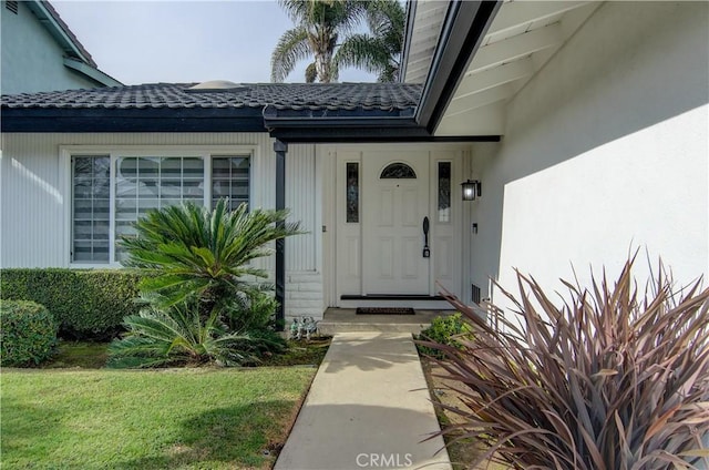 entrance to property featuring a lawn