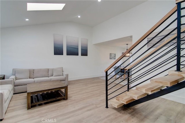 living room featuring a chandelier, lofted ceiling, and light wood-type flooring