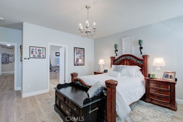 bedroom featuring a chandelier, light hardwood / wood-style floors, and ensuite bath