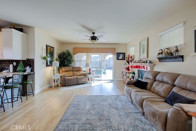 living room with ceiling fan and light wood-type flooring