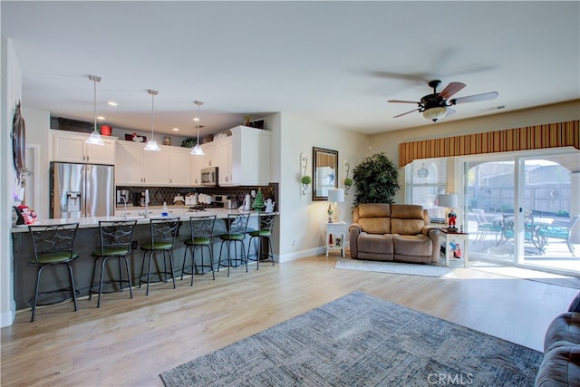 living room with ceiling fan and light hardwood / wood-style floors