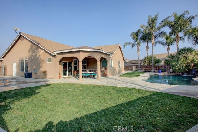 back of house with a fenced in pool, a yard, and a patio