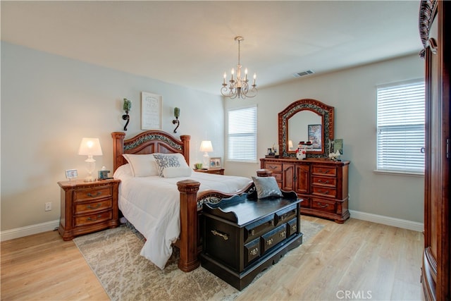 bedroom with an inviting chandelier and light wood-type flooring