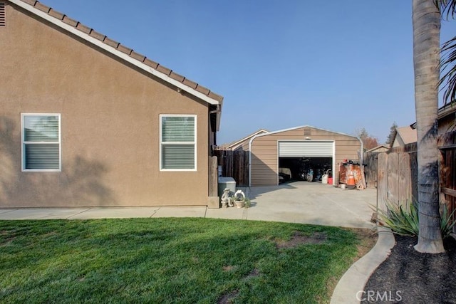 view of property exterior featuring a lawn, an outbuilding, and a garage