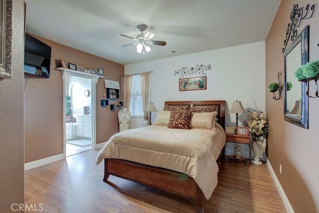 bedroom with ensuite bathroom, hardwood / wood-style floors, and ceiling fan