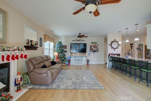 living room with light wood-type flooring and ceiling fan