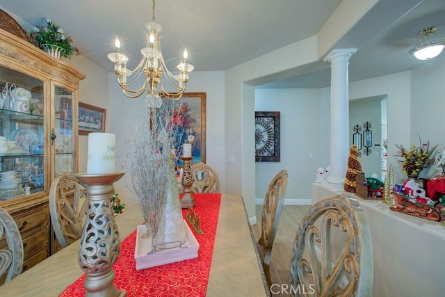 dining area featuring a notable chandelier and decorative columns