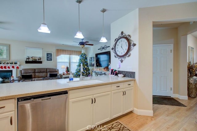 kitchen featuring light wood-type flooring, ceiling fan, sink, pendant lighting, and dishwasher