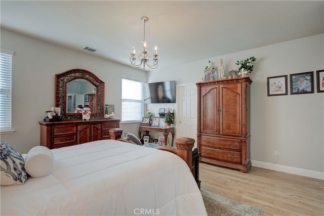 bedroom with a chandelier and light hardwood / wood-style flooring