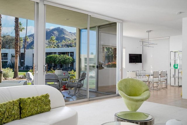 living room with light tile patterned floors, a wall of windows, and a wealth of natural light