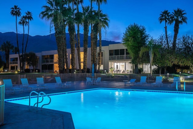 pool at dusk with a mountain view and a patio area