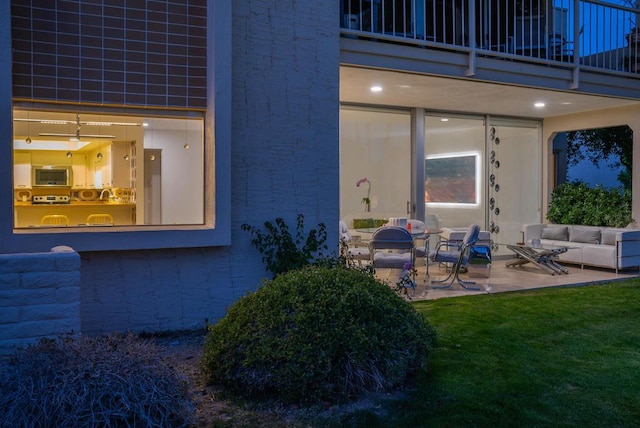 property entrance featuring a yard, outdoor lounge area, a balcony, and a patio