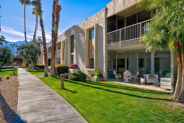 view of property's community with a lawn and a patio