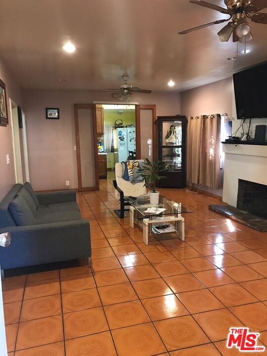 tiled living room featuring ceiling fan