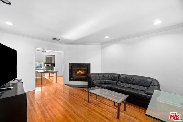 living room with a fireplace, hardwood / wood-style floors, and ornamental molding