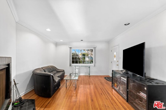 living room with a fireplace, light hardwood / wood-style floors, and ornamental molding