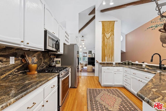 kitchen with white cabinetry, sink, stainless steel appliances, vaulted ceiling with beams, and light wood-type flooring