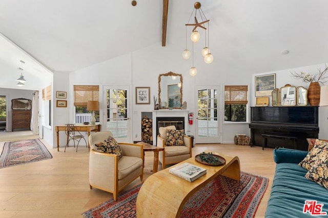 living room with a healthy amount of sunlight, light hardwood / wood-style floors, beam ceiling, and high vaulted ceiling