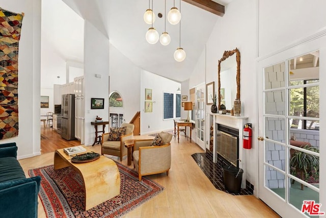 living room with beamed ceiling, high vaulted ceiling, and light hardwood / wood-style floors