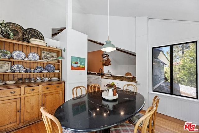 dining room with light hardwood / wood-style floors and lofted ceiling