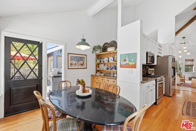 dining room with beam ceiling, high vaulted ceiling, and light wood-type flooring