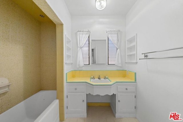 bathroom with tile patterned flooring, vanity, and a washtub