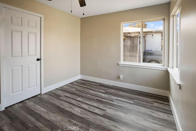 empty room with ceiling fan and dark hardwood / wood-style flooring