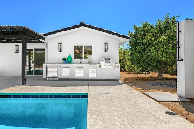 back of property with a patio, area for grilling, and sink