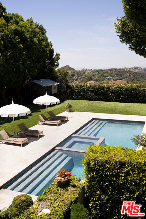 view of swimming pool with a mountain view, a yard, and a patio area