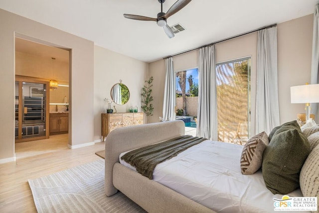 bedroom featuring access to exterior, ensuite bathroom, light hardwood / wood-style flooring, and ceiling fan