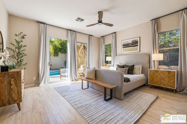 bedroom featuring access to exterior, light hardwood / wood-style floors, multiple windows, and ceiling fan