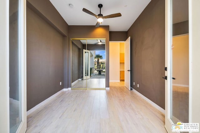 empty room with french doors, light hardwood / wood-style flooring, and ceiling fan