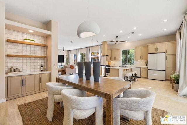 dining area with ceiling fan and light wood-type flooring