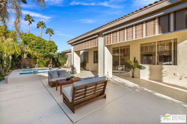 view of patio featuring a swimming pool with hot tub and an outdoor hangout area