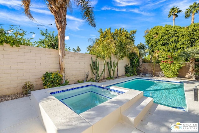 view of pool featuring an in ground hot tub