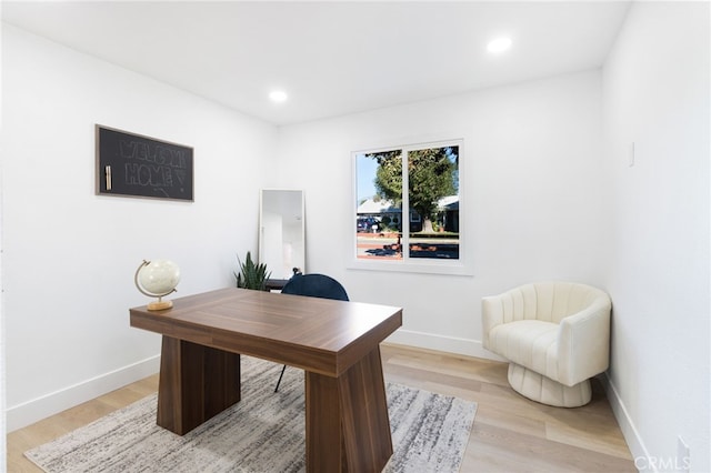 home office with light hardwood / wood-style floors