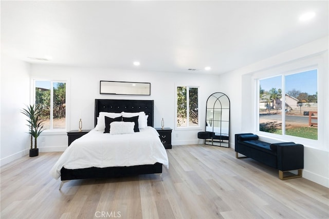 bedroom with light wood-type flooring and multiple windows