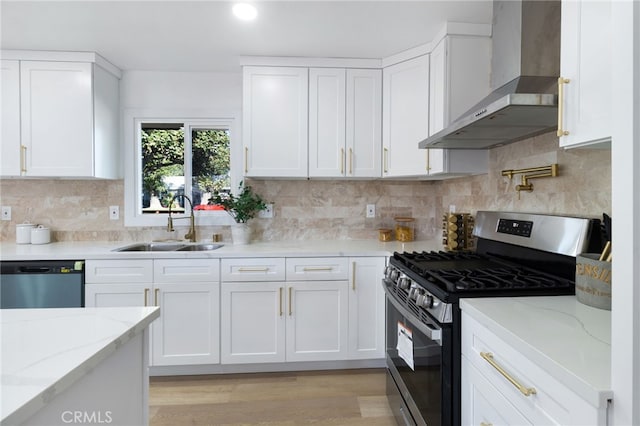 kitchen featuring white cabinetry, sink, wall chimney range hood, and stainless steel appliances