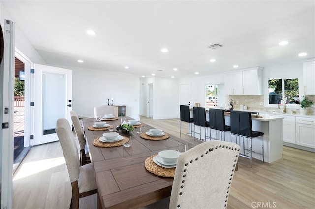 dining space with sink and light hardwood / wood-style flooring