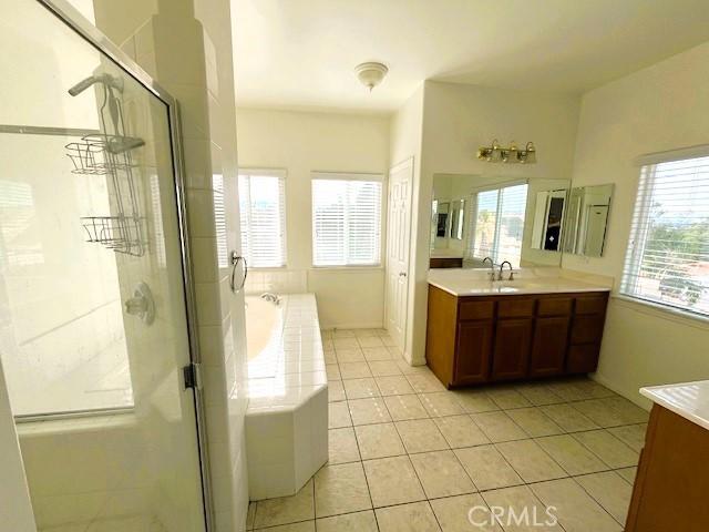 bathroom with tile patterned floors, vanity, and independent shower and bath